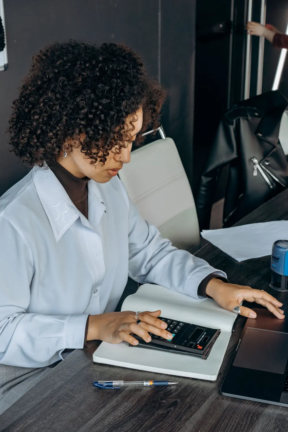 African businesswoman reviewing figures with a calculator