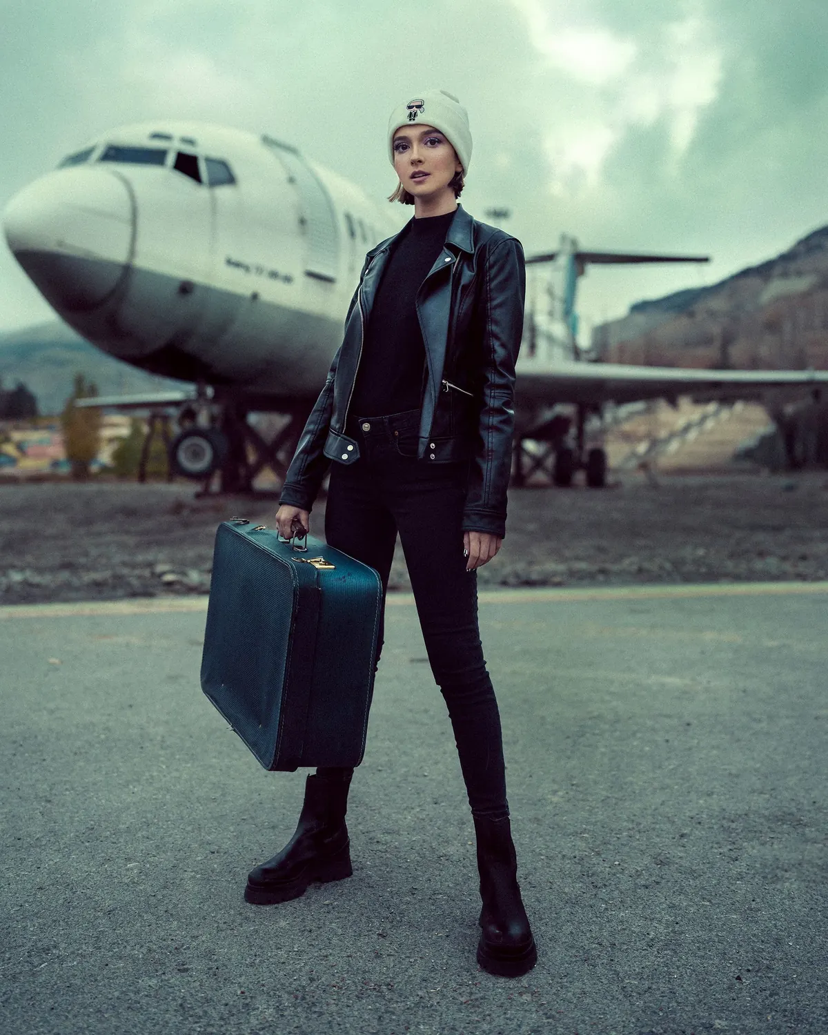 Business traveler walking beside an aircraft with luggage