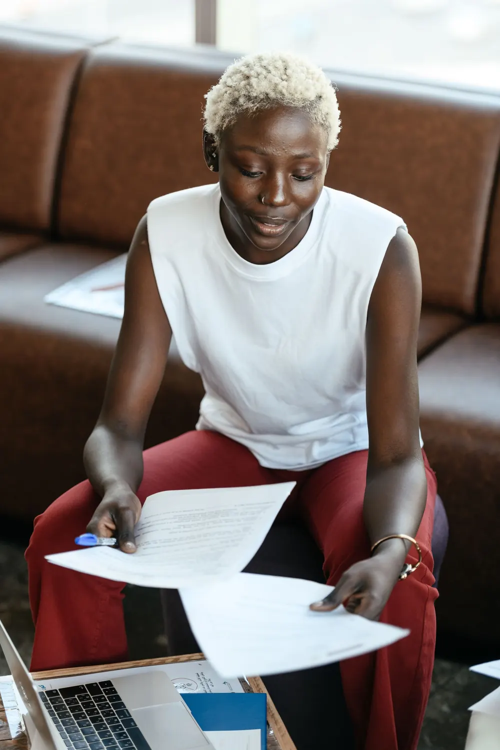 Professional reviewing documents at a laptop